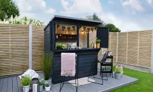 Svart utomhusbar med "GIN BAR"-girlang, perfekt för att bygga bar-drömmar i trädgården. Ljus och inbjudande.