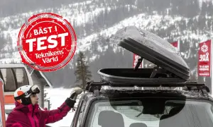 En person med skidor och hjälm förbereder en takbox för en skidresa. "Bäst i test"-märkning syns.