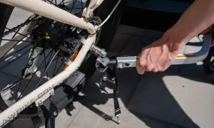 Hand fäster en Thule Ezhitch-koppling på en elcykel för att dra en cykelkärra.