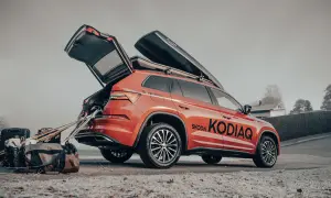 En orange Skoda Kodiaq redo för vinterns äventyr med takboxar och packning.