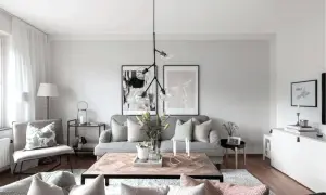 Mysigt vardagsrum med grå soffa, träbord och konst. Perfekt för små vardagsrum.