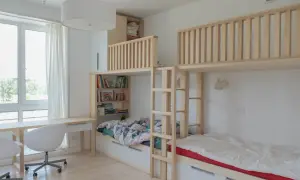 Syskonrum med smart inredning för barn som delar rum. Våningssängar i trä med förvaring och en mysig läshörna.