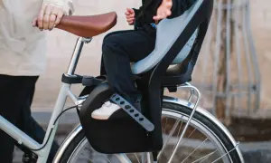 Ett barn sitter tryggt i en cykelbarnstol, redo för en tur.