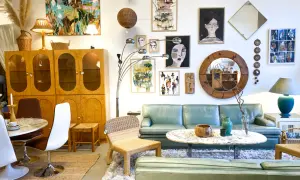En ljus och luftig butik med 60 tals inredning. En ljusgrön soffa, teakskåp, konst och speglar skapar en retrokänsla.