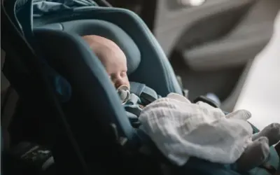 Sovande bebis med napp i en Thule babysitter, tryggt och bekvämt för resan.