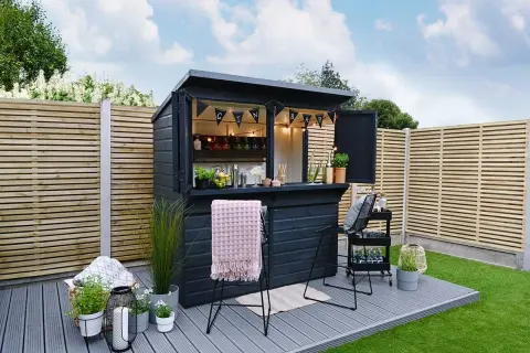Svart utomhusbar med "GIN BAR"-girlang, perfekt för att bygga bar-drömmar i trädgården. Ljus och inbjudande.