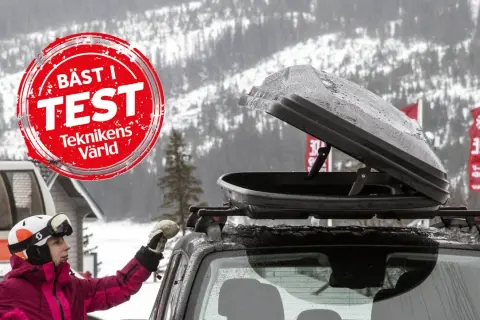 En person med skidor och hjälm förbereder en takbox för en skidresa. "Bäst i test"-märkning syns.