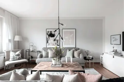 Mysigt vardagsrum med grå soffa, träbord och konst. Perfekt för små vardagsrum.