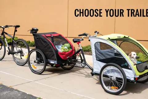 Två cyklar med cykelvagnar. En röd vagn med mat och en ljusgrå med en hund. Välj din trailer!