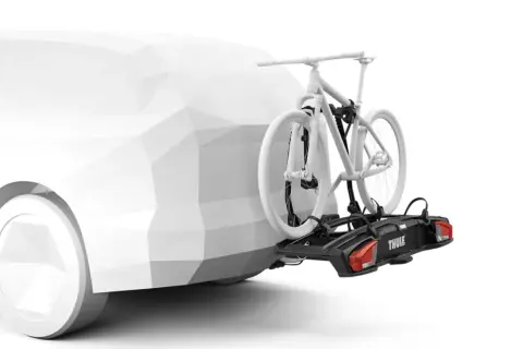 En vit cykel på en svart cykelhållare, ett smart thule tillbehör, monterad på en vit bil.