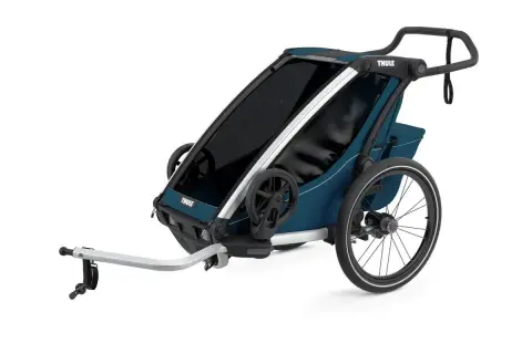 En blå Thule Chariot Lite barnvagn med silverdetaljer och stora hjul, redo för äventyr.