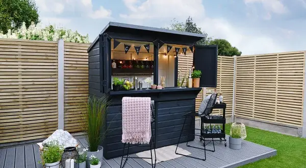 Svart utomhusbar med "GIN BAR"-girlang, perfekt för att bygga bar-drömmar i trädgården. Ljus och inbjudande.