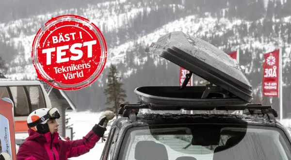En person med skidor och hjälm förbereder en takbox för en skidresa. "Bäst i test"-märkning syns.