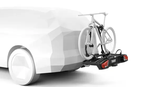 En vit cykel på en svart cykelhållare, ett smart thule tillbehör, monterad på en vit bil.