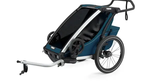 En blå Thule Chariot Lite barnvagn med silverdetaljer och stora hjul, redo för äventyr.
