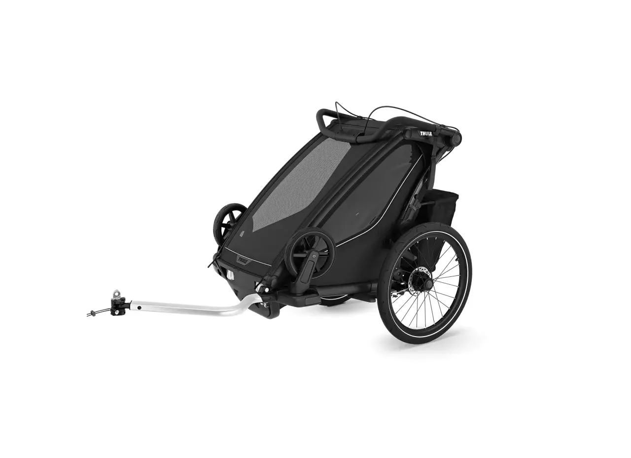 Svart cykelvagn för bebis med stora hjul och dragstång. Perfekt för äventyr med familjen.