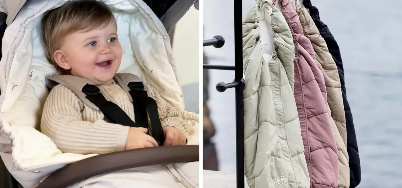 Glad baby i barnvagnen, redo för en härlig barnvagn sommar. Bredvid hänger varma åkpåsar i olika färger.