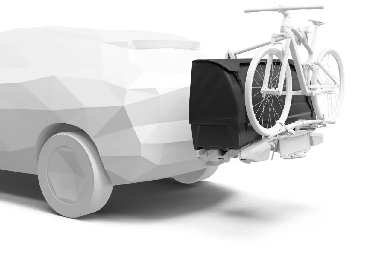 En vit cykel p&aring; en svart f&ouml;rvaringsbox monterad p&aring; en bil. Thule XT-systemet ger plats f&ouml;r b&aring;de cykel och packning.