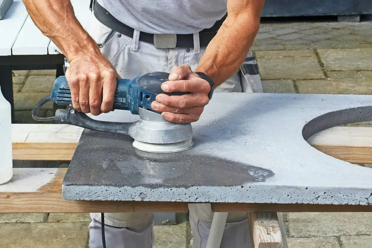 H&auml;nder slipar betonggolv med en maskin.