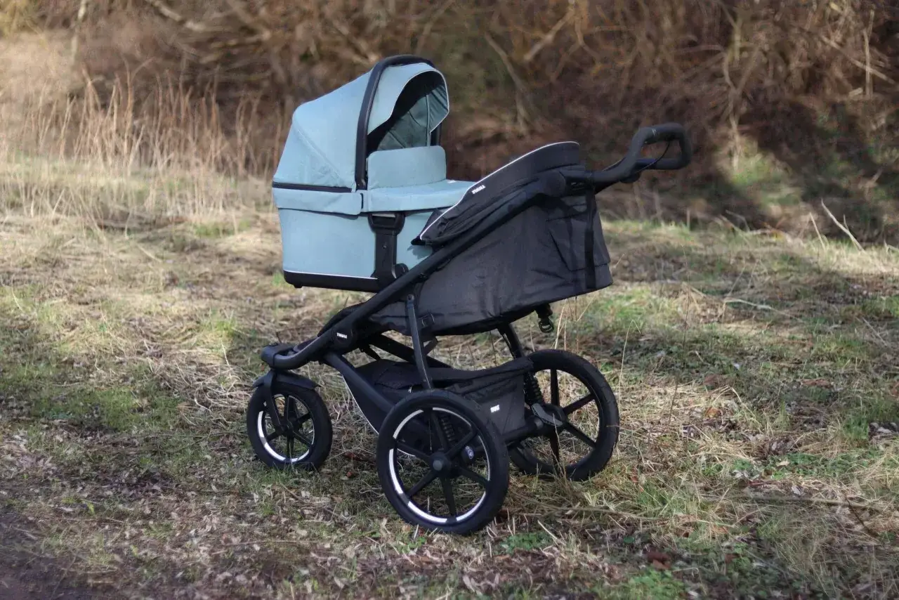 En ljusbl&aring; Thule Urban Glide liggdel p&aring; ett svart chassi, redo f&ouml;r &auml;ventyr i naturen.