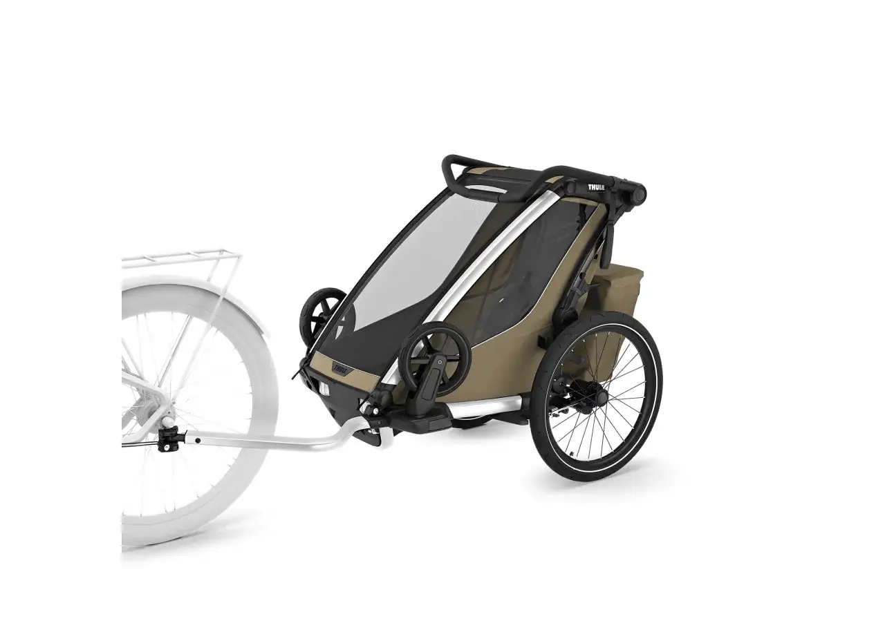 Thule Chariot Cross 2 cykelvagn i beige, kopplad till en vit cykel. Perfekt f&ouml;r &auml;ventyr med barnen.