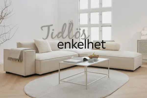 En tidlös soffa i ljusbeige, designad av svenska designers, med en vit soffbordsbok och fruktskål.